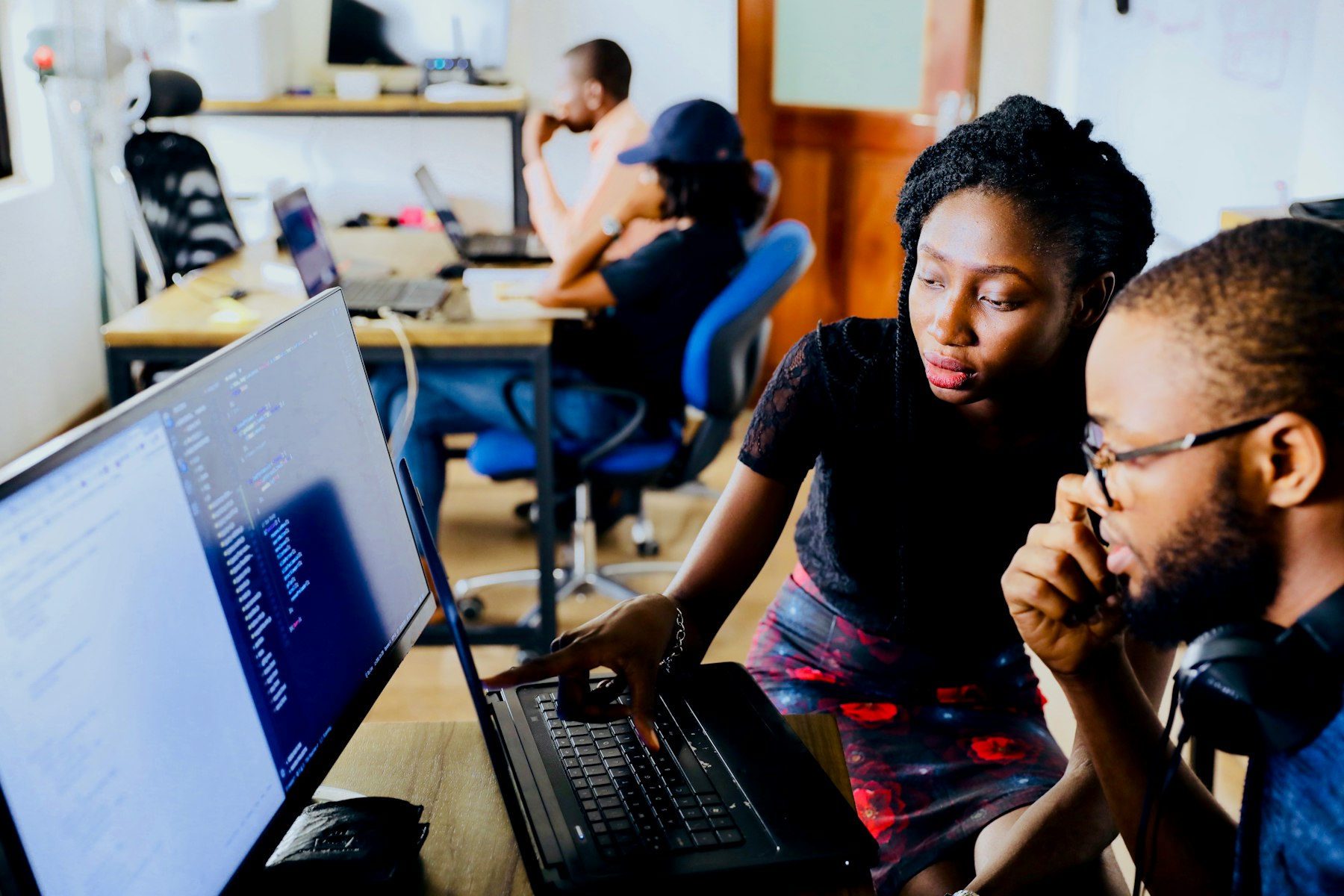Two developers reviewing code together on a monitor