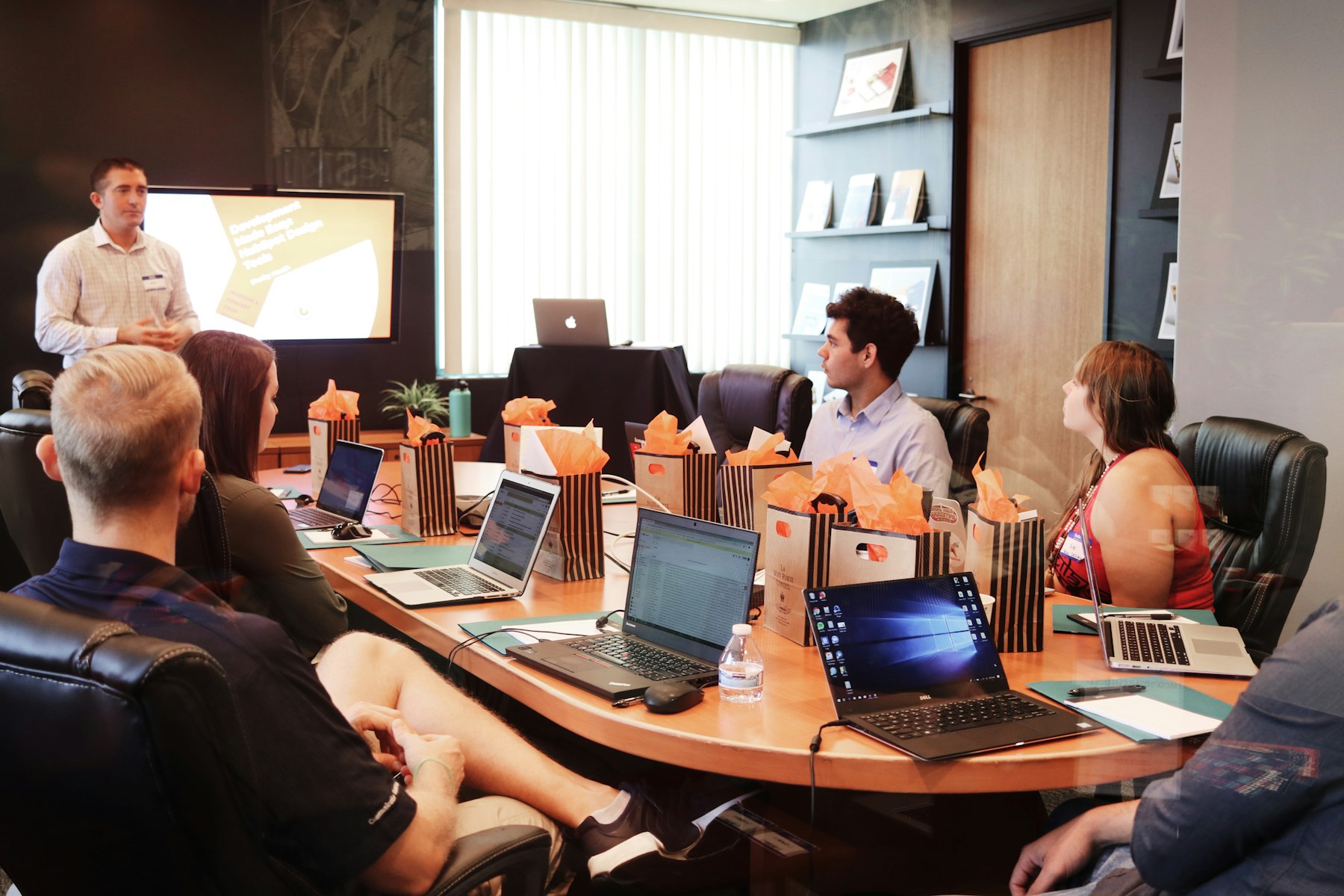 A presenter leading a workshop for a room of participants with laptops